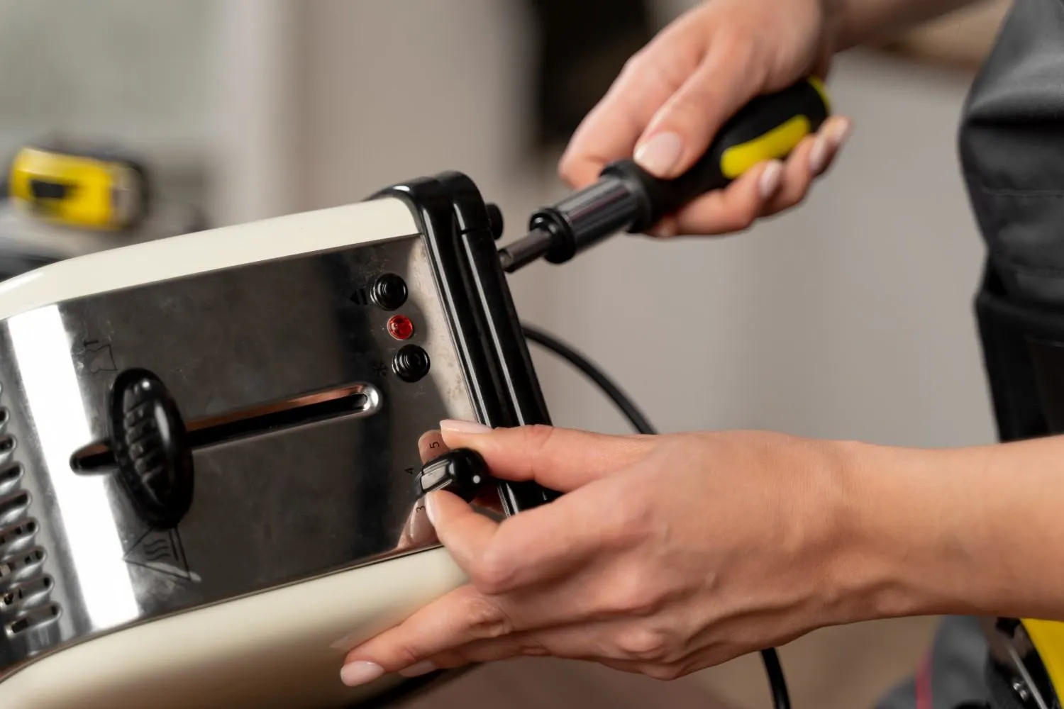 Screwdriver opening the casing of a small kitchen appliance